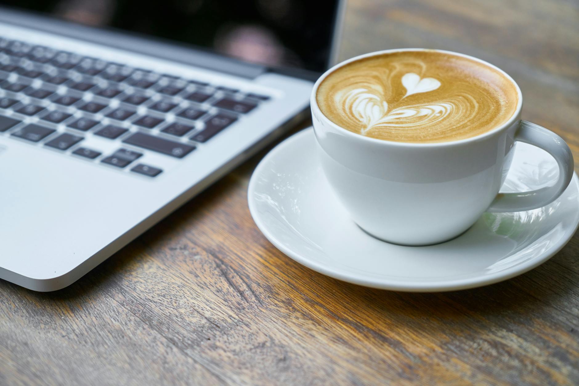 Laptop with coffee beside it on a table. Understanding how to pick your blog niche