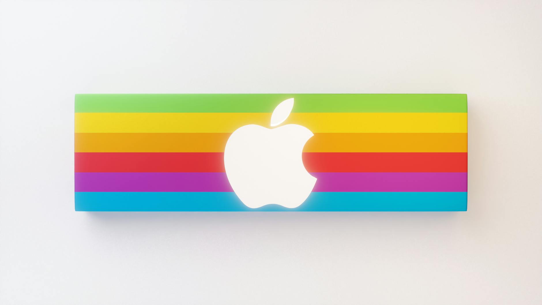 An image of Apple with it's previous coloured rainbow branding with the new logo over top. Showing that brands evolve over time